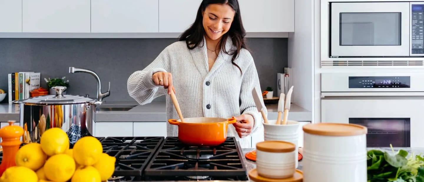 A woman cooking in the kitchen, looking happy