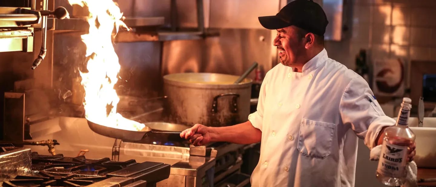 A chef using a frying pan in the kitchen