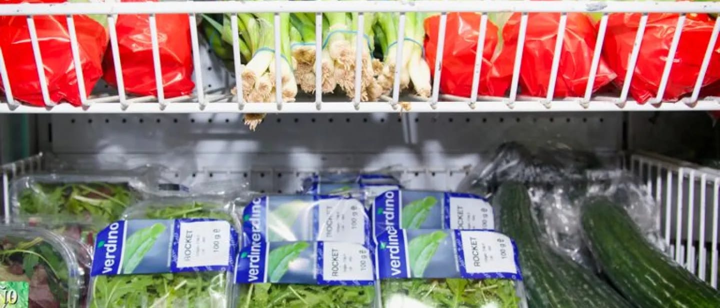 Leafy greens presented on supermarket produce shelving