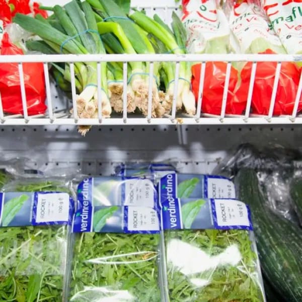 Leafy greens presented on supermarket produce shelving